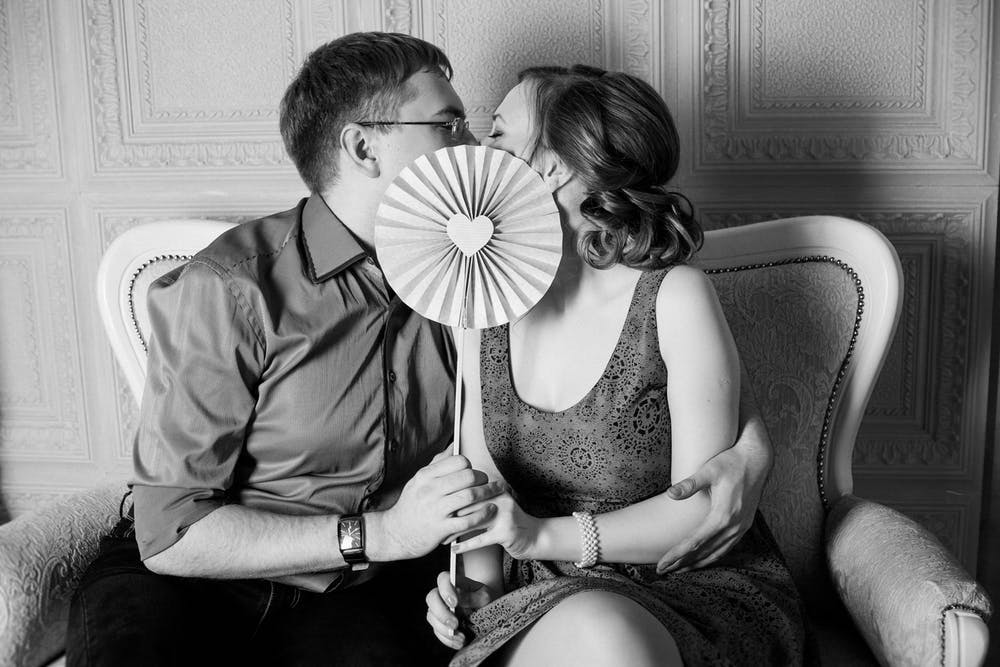 Couple Holding Fan Kissing